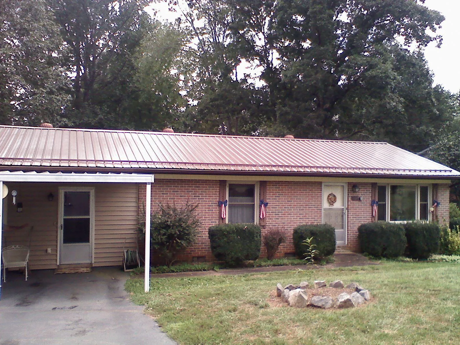 Bronze metal roof and carport on a brick ranch home — Roof Repair work by our crew in Powell